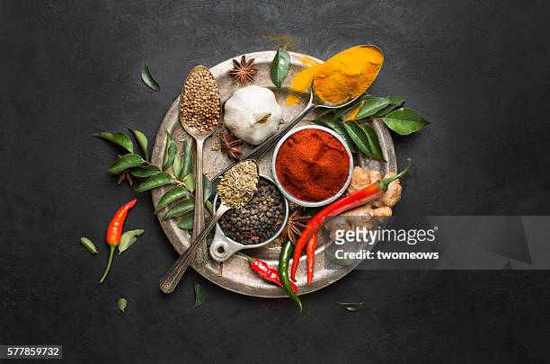 flat lay overhead view herb and spices on textured black background. - seasoning - fotografias e filmes do acervo