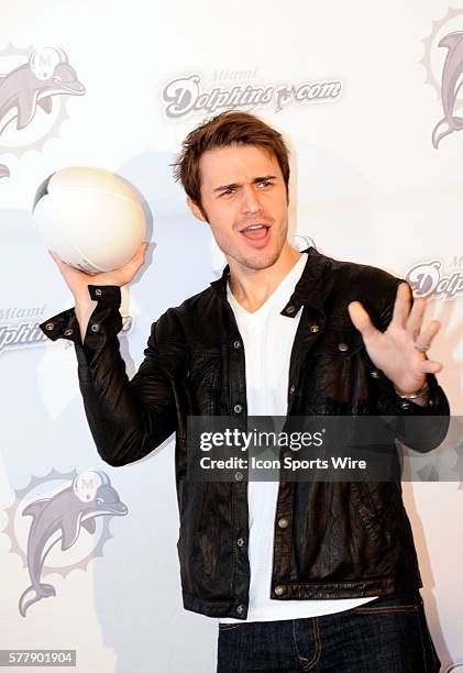 American Idol winner Kris Allen poses with a football on the the orange carpet before the start of the NFL game between the Cleveland Browns and the...