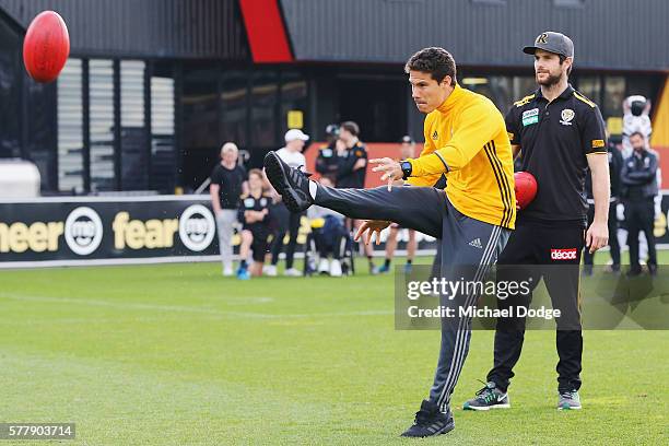 Trent Cotchin of the Tigers watches Hernanes of Juventus kick an AFL football during a Richmond Tigers AFL and Juventus FC media opportunity at Punt...