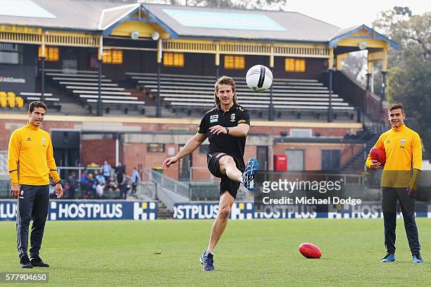 Ivan Maric of the Tigers kicks a soccer ball between Hernanes and Paulo Dybala of Juventus during a Richmond Tigers AFL and Juventus FC media...
