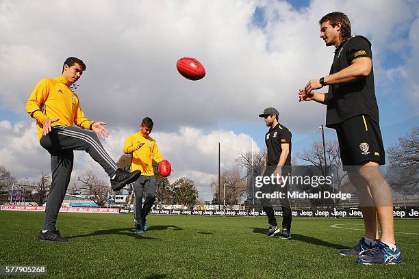 Trent Cotchin and Ivan Maric of the Tigers watch Hernanes have a kick of an AFL football with Paulo Dybala and Hernanes of Juventus during a Richmond...