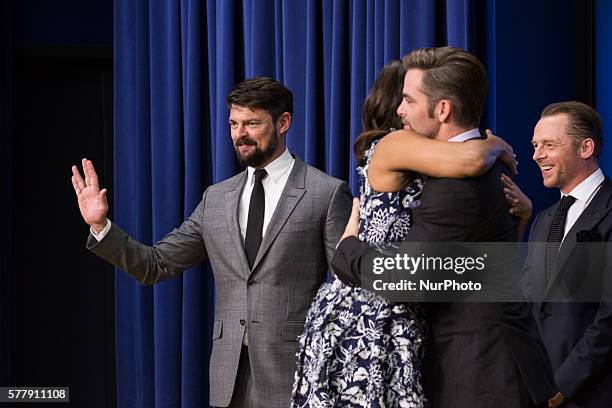 On Tuesday, July 19, in the auditorium of the Eisenhower Executive Office Building, First Lady Michelle Obama, hugs Chris Pine, as Karl Urban, gives...