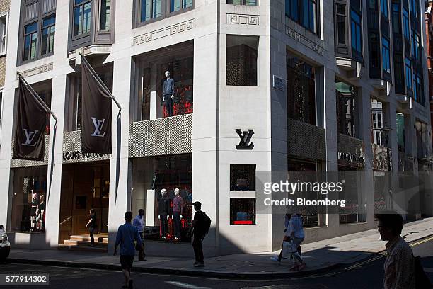 Pedestrians walk past the Louis Vuitton Maison, the London flagship store for LVMH Moet Hennessy Louis Vuitton SA, on New Bond Street in London,...