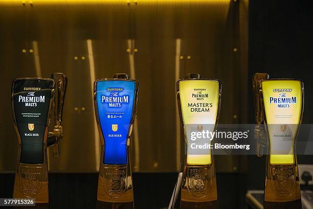 Taps of Suntory Holdings Ltd.'s The Premium Malt's Black beer, from left, Ale beer, Master's Dream and Pilsner beer stand at the bar at the company's...