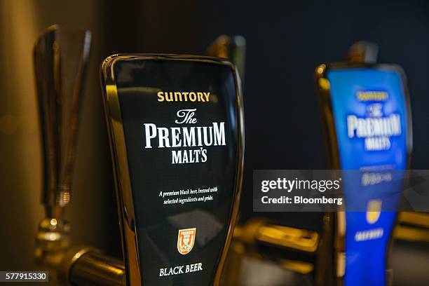 Taps of Suntory Holdings Ltd.'s The Premium Malt's Black beer, left, and Ale beer stand at the bar at the company's Master House bar in Hong Kong,...