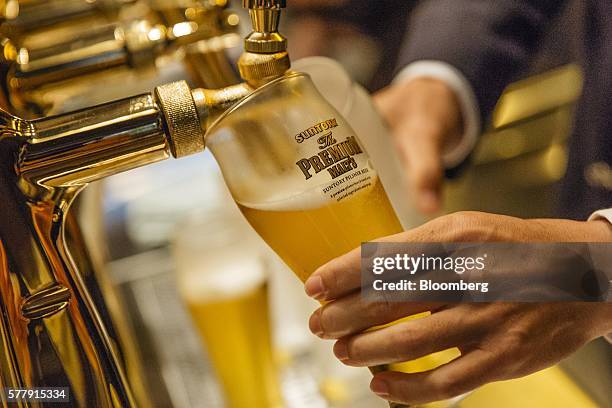 Bartender pours a glass of Suntory Holdings Ltd.'s The Premium Malt's Pilsner beer at the company's Master House bar in Hong Kong, China, on...