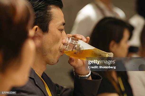 Member of the media drinks a glass of Suntory Holdings Ltd.'s The Premium Malt's Pilsner beer at the company's Master House bar in Hong Kong, China,...