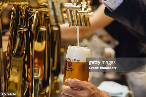 Tetsu Mizutani, president of Suntory Beer Ltd., pours a glass of Suntory Holdings Ltd.'s The Premium Malt's Master's Dream beer at the company's...