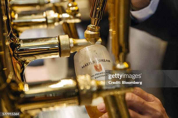 Bartender pours a glass of Suntory Holdings Ltd.'s The Premium Malt's Master's Dream beer at the company's Master House bar in Hong Kong, China, on...