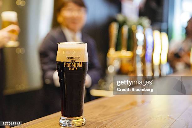 Glass of Suntory Holdings Ltd.'s The Premium Malt's Black beer is arranged for a photograph at the company's Master House bar in Hong Kong, China, on...