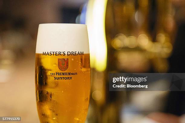 Glass of Suntory Holdings Ltd.'s The Premium Malt's Master's Dream beer is arranged for a photograph at the company's Master House bar in Hong Kong,...