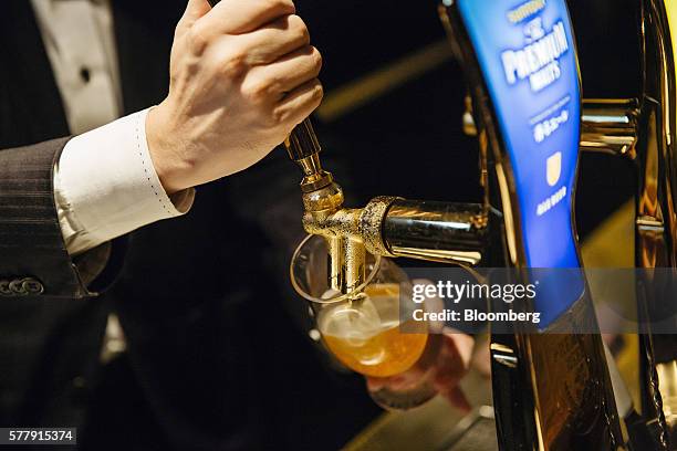 Bartender pours a glass of Suntory Holdings Ltd.'s The Premium Malt's Ale beer at the company's Master House bar in Hong Kong, China, on Wednesday,...