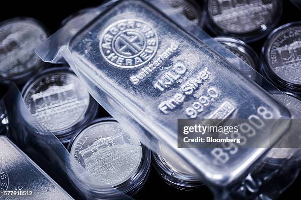 One kilogram silver bar, produced by Swiss manufacturer Argor Hebaeus SA, sits on top of Austria Vienna Philharmonic commemorative silver coins,...