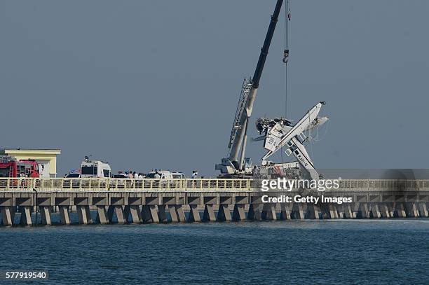 Crane works to lift wreckage of a seaplane as the seaplane carrying 10 people hit a bridge and crashed in its debut flight on July 20, 2016 in...