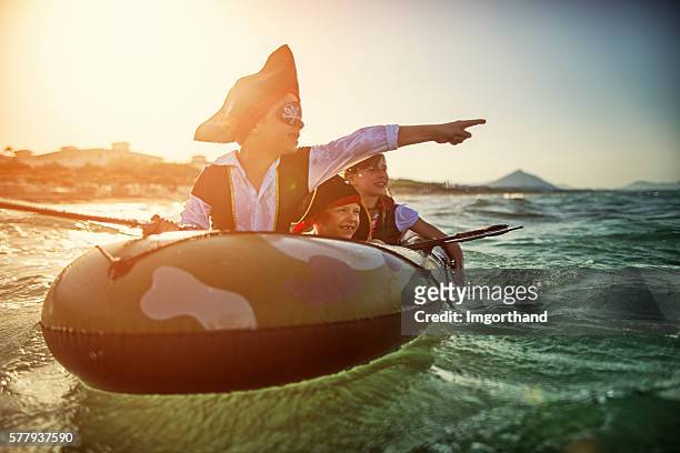 kinder spielen piraten auf see auf einem boot - boy exploring on beach stock-fotos und bilder