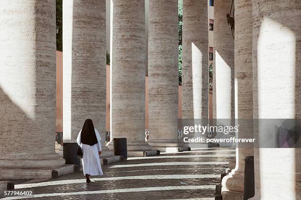 nonne marchant parmi la colonnade du bernin sur la place saint-pierre, vatican - religieuse photos et images de collection