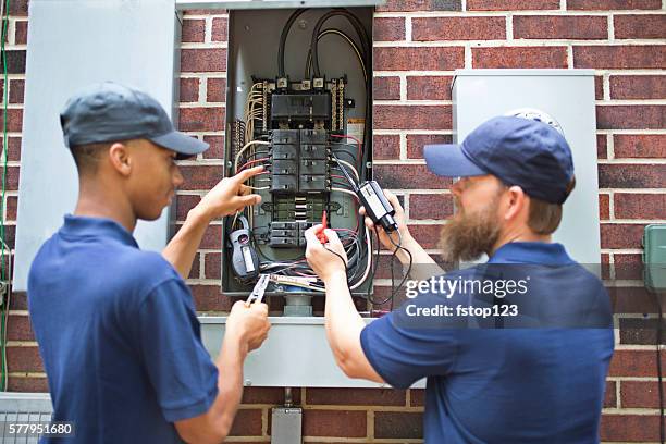 repairmen, electricians working on home breaker box. - power line repair stock pictures, royalty-free photos & images