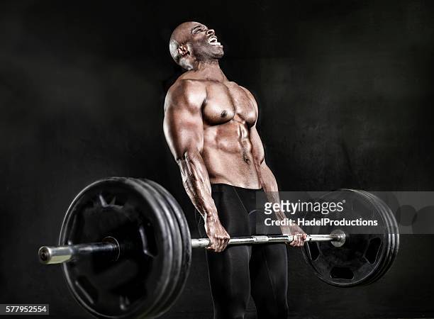 athlete lifting heavy weights - weight lifting stockfoto's en -beelden