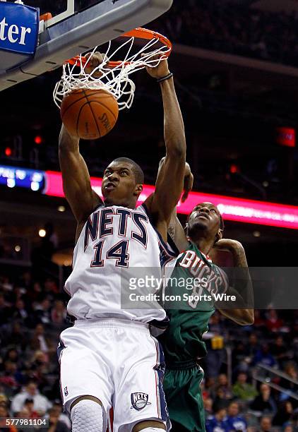 New Jersey Nets power forward Derrick Favors dunks in front of Milwaukee Bucks power forward Larry Sanders at the Prudential Center in January 8,...
