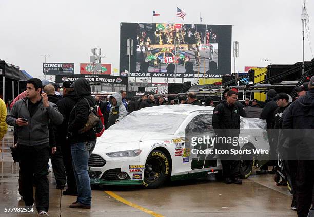 Travis Kvapil's team brings his car through inspection in the rain before the NASCAR Sprint Cup Series Duck Commander 500 at Texas Motor Speedway in...