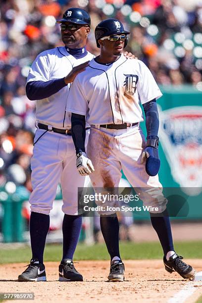 Detroit Tigers third base coach Dave Clark pats Detroit Tigers left fielder Rajai Davis on the back during the fifth inning of a regular season game...