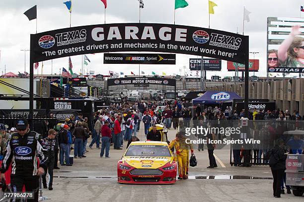 Crew members of Joey Logano, driver of the Shell Pennzoil Ford push the car out to the starting grid before Logano took the checkered flag in the...