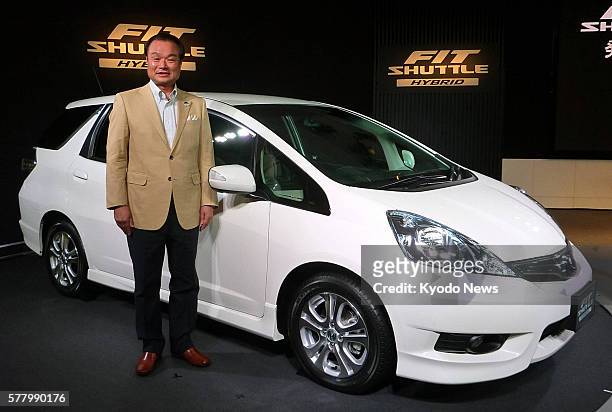 Japan - Honda Motor Co. President Takanobu Ito stands beside the Fit Shuttle, the automaker's new compact wagon model, at the company's headquarters...