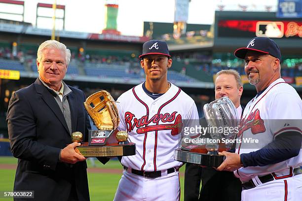 Atlanta Braves General Manager Frank Wren and manager Fredi Gonzalez present shortstop Andrelton Simmons with the Rawlings Golden Glove Award and the...