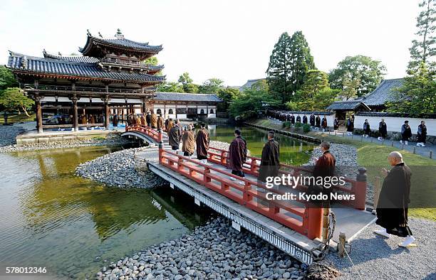 Uji, Japan - Buddhist monks walk toward the Phoenix Hall, a Japanese national treasure, at Byodoin temple in Uji, Kyoto Prefecture, on June 21 for a...