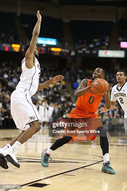 Miami Hurricanes guard Ja'Quan Newton looks for a shot guarded by Wake Forest Demon Deacons forward Aaron Rountree III during the ACC matchup between...