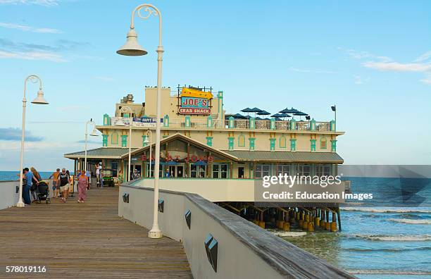 Daytona Beach Florida famous Main Street Pier and Boardwalk pier with restaurant Joes Crab Shack on water for tourists with boardwalk at World's Most...