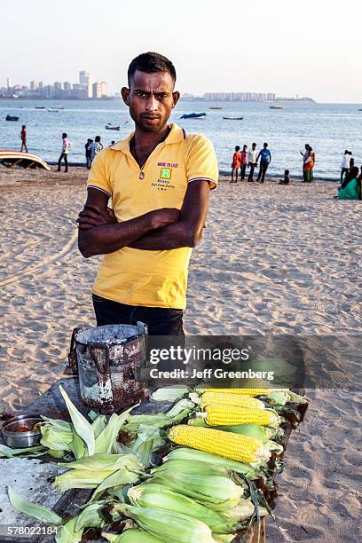 India Mumbai Girgaon Marine Drive Chowpatty Beach public vendor roasted corn on cob man Arabian Sea.