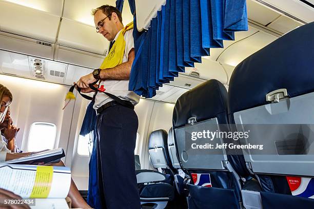 South Africa Johannesburg O. R. Tambo International Airport inside BA British Airways commercial airliner man flight attendant safety demonstration...