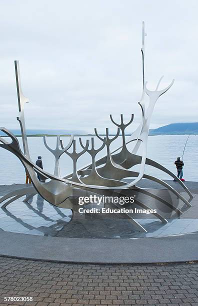 Reykjavik Iceland downtown Harbor Sculpture Sun Voyager Viking Ship artist Jon Gunnar Arnason with fisherman.