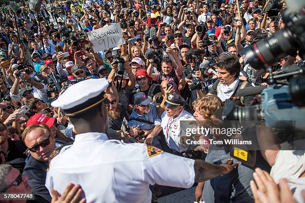 Police separate radio host Alex Jones, second from left, from other protesters in the Public Square near the Republican National Convention at the...