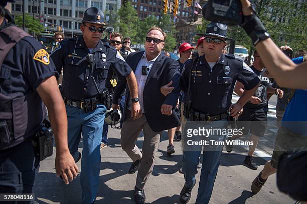 Radio host Alex Jones is escorted from a rally in the Public Square after inciting a confrontation near the Republican National Convention at the...