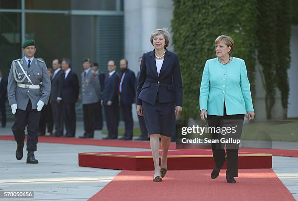 German Chancellor Angela Merkel and British Prime Minister Theresa May review a guard of honor upon May's arrival at the Chancellery on July 20, 2016...
