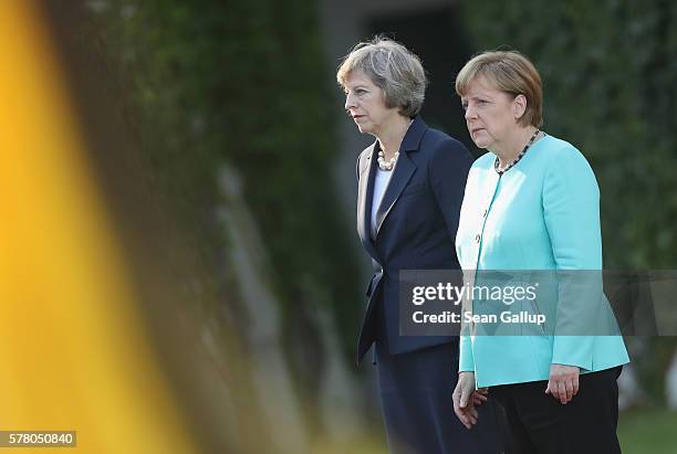 German Chancellor Angela Merkel and British Prime Minister Theresa May review a guard of honor upon May's arrival at the Chancellery on July 20, 2016...
