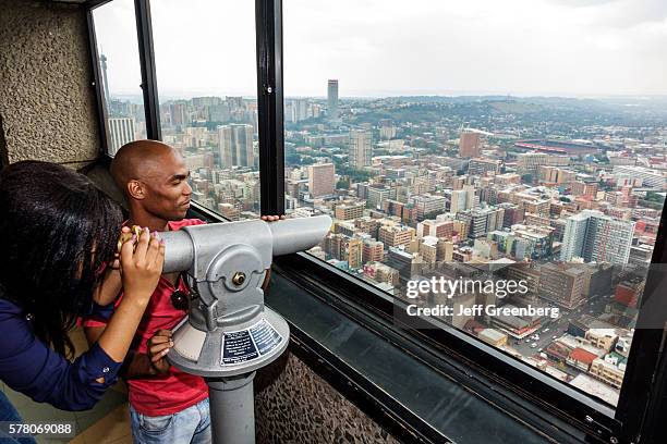 South Africa Johannesburg Carlton Centre center Top of Africa observatory deck view from man woman couple looking buildings city using telescopic...