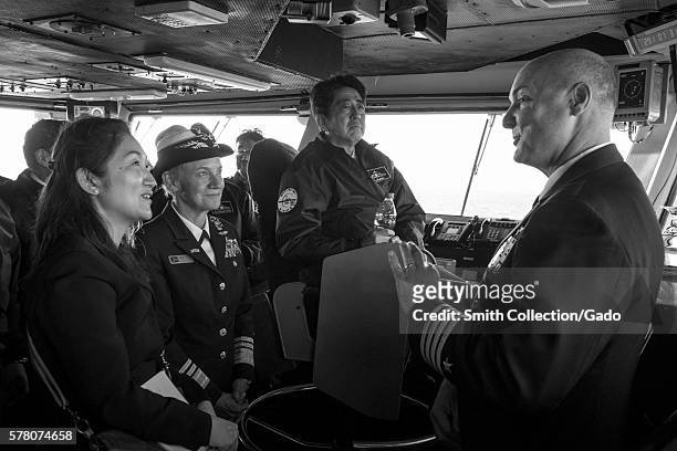 Capt Christopher Bolt, right, commanding officer of the US Navy's only forward-deployed aircraft carrier USS Ronald Reagan CVN 76, explains flight...