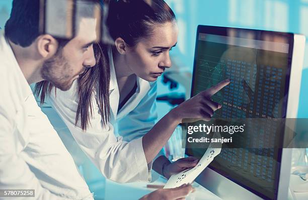 scientist interacting with the computer via touch screen - physics 個照片及圖片檔