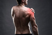Pain in the shoulder. Muscular male body.