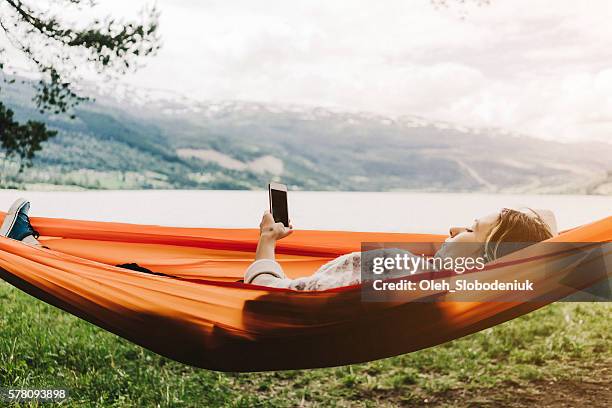 woman in hammock - woman smartphone nature stockfoto's en -beelden