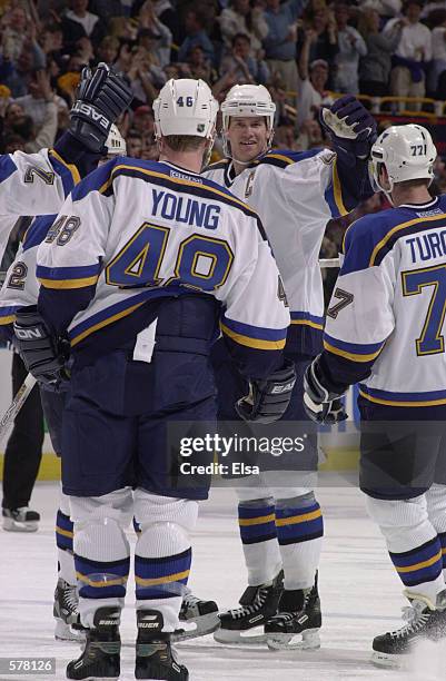 Chris Pronger of the St. Louis Blues celebrates with his teammates Scott Young and Pierre Turgeon during game 1 of the western conference playoffs...