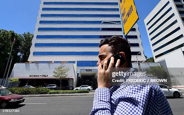 Pedestrian speaks on his cellphone while walking past the building on Sunset Boulevard in West Hollywood, California on July 20 where Red Granite...