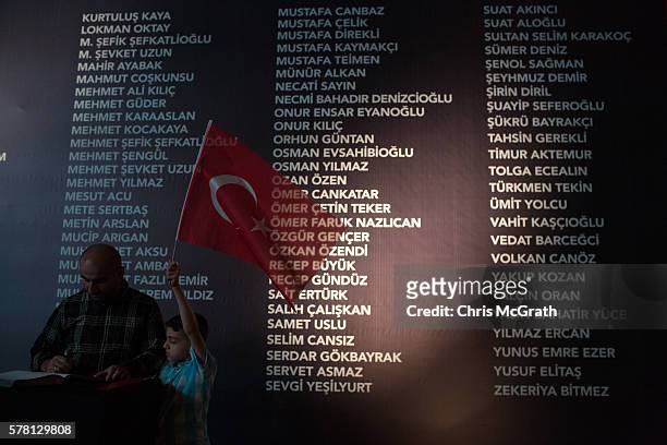 Young boy holds a Turkish flag in front of a board listing the names of people killed during the failed coup attempt at Taksim Square on July 20,...