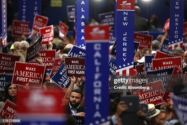 Delegates hold signs reading "Make America First Again" during the Republican National Convention in Cleveland, Ohio, U.S., on Wednesday, July 20,...