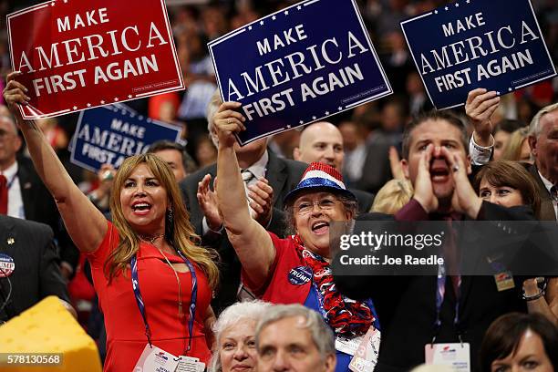 Delegates hold up signs that read "Make America First Again" during the opening of the third day of the Republican National Convention on July 20,...