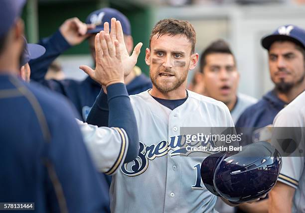 Will Middlebrooks of the Milwaukee Brewers is greeted by teammates in the dugout after coming around to score in the second inning during the game...