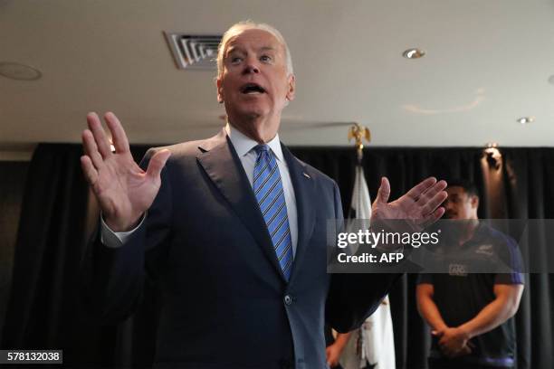 Vice President Joe Biden gestures after receiving a personalised All Black rugby jersey from players Jerome Kaino and Charlie Faumuina during his...